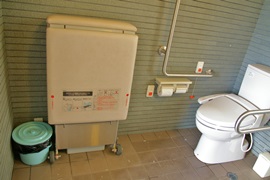 国崎漁港公衆トイレ　右側に便器、左側に二つ折りに畳まれたユニバーサルシート